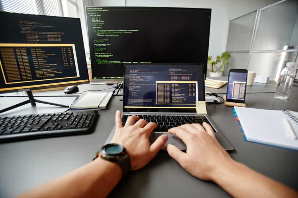 Programmer working with several screens.